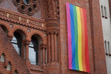 Große Regenbogenfahne an der Fassade einer Kirche in Berlin