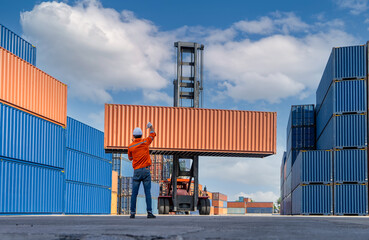 Engineers are overseeing the transportation of cargo with containers inside the warehouse....