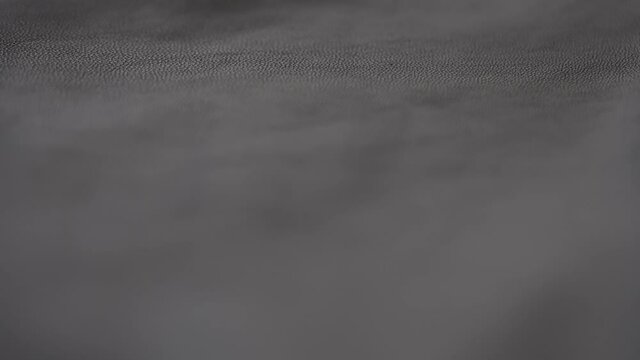 Slow motion handheld shot of soft gray brown leather closeup