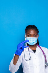 healthcare, vaccination, anesthesia and medical concept - african american female doctor holding syringe with injection isolated over blue background