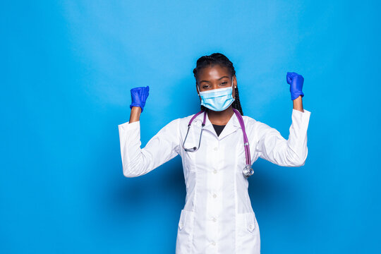 Waist Up Portrait Of Strong Successful Determined Young African American Doctor Woman Raising Arms, Clenching Fists, Exclaiming With Joy And Excitement. Victory, Success And Achievement Concept.