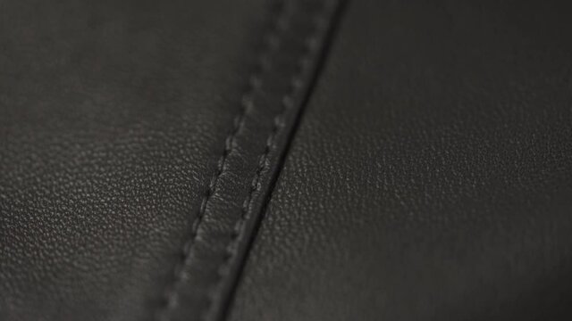 Slow motion handheld shot of soft gray brown leather closeup