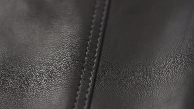 Slow motion handheld shot of soft gray brown leather closeup
