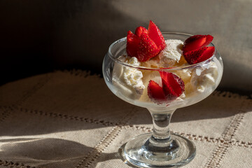 Ice cream sundae with strawberries. Advertising background for ice cream. Simple glass ice cream bowl.