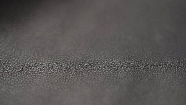 Slow motion handheld shot of soft gray brown leather closeup