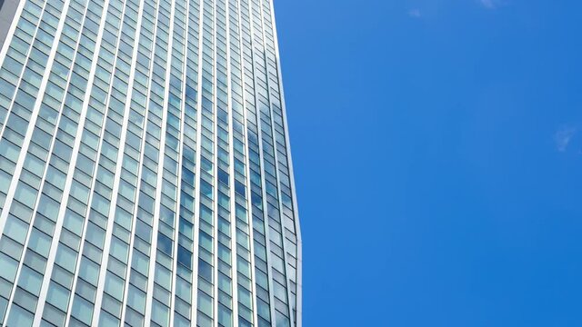 ビジネスイメージ　タイムラプス 高層ビルの窓に映る空と雲