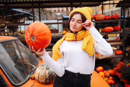 Young pretty woman holding orange halloween pumpkin. - Powered by Adobe