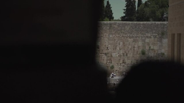Crowd of Jewish prayers at the Kotel western wall in Jerusalem, Israel. Side view long shot of people praying and worship to god at Cotel east Jerusalem, old city King David city