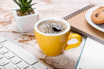 Cup of aromatic coffee on table in office