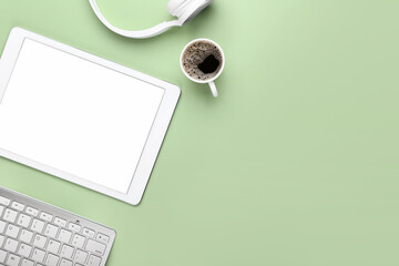 Tablet computer, keyboard and cup of coffee on color background