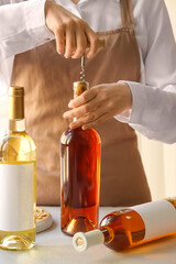 Woman opening bottle of wine at table