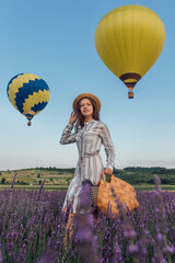 Young woman with lavender bouquet basket on sky aerostats background