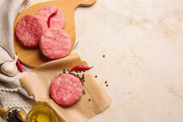 Composition with raw cutlets made of fresh forcemeat on light background