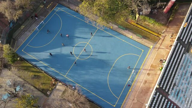 Aerial Top Down Showing Children Playing Hobby Soccer On Blue Amateur Soccer Court In Buenos Aires