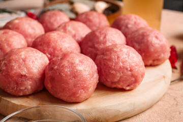 Wooden board with raw cutlets made of fresh forcemeat on table, closeup