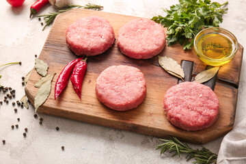 Composition with raw cutlets made of fresh forcemeat on light background
