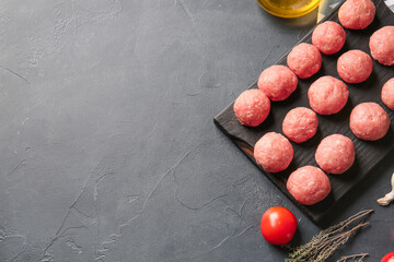 Composition with raw cutlets made of fresh forcemeat on dark background