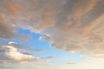 Clear blue sky, pink and golden cirrus and cumulus clouds after storm at sunset. Dramatic...