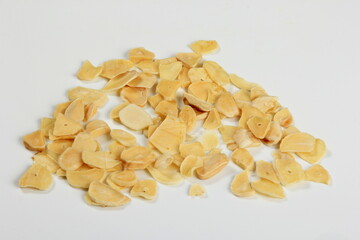 Dried garlic flakes on white background. Dried vegetables