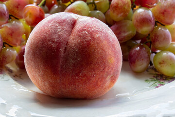 Fruit plate with grapes, apricot and almond on black plate and gray background