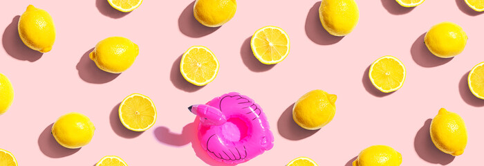 Summer concept with a pink flamingo float and lemons