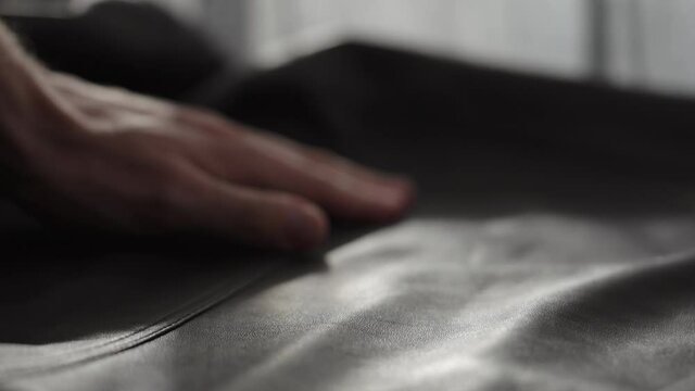 Slow motion shot man touching fine leather closeup