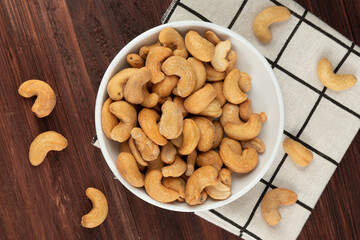 Top view of cashew nuts in white bowl on the table, Flat lay, Healthy snack, Vegetarian food.