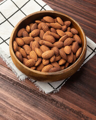 Almonds in wooden bowl on the table, Healthy snack, Vegetarian food.