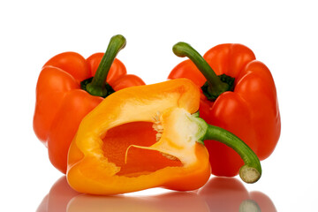 One half and two whole organic bell peppers, close-up, isolated on white.
