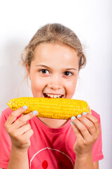 Girl eating corn. Healthy food for children.