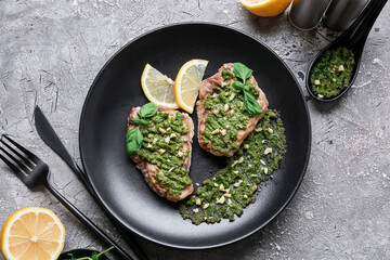 Composition with tasty steaks and sauce pesto on grunge background