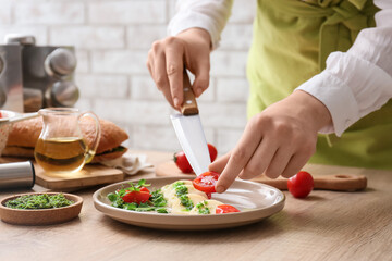 Obraz na płótnie Canvas Woman preparing caprese salad with pesto sauce in kitchen