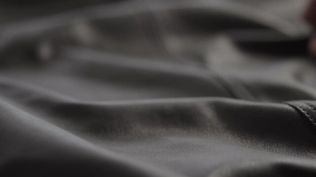 Slow motion shot man touching fine leather closeup