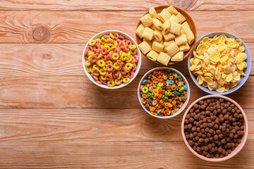 Bowls with tasty cereals on wooden background