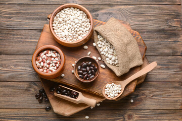 Composition with different types of beans on wooden background