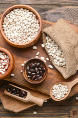 Composition with different types of beans on wooden background