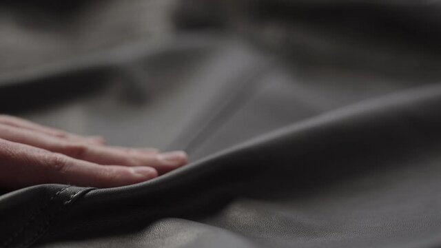 Slow motion shot man touching fine leather closeup