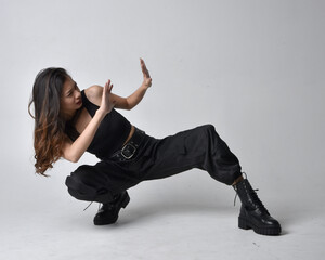 Full length portrait of pretty young asian girl wearing black tank top, utilitarian  pants and...