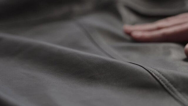 Slow motion shot man touching fine leather closeup