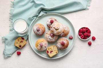 Tray with tasty raspberry muffins and glass of milk on light background
