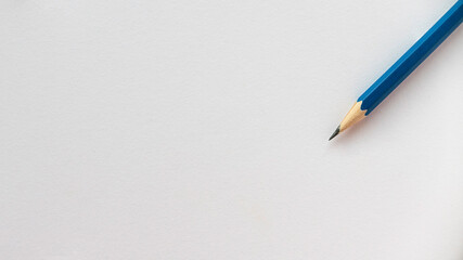 Blue pencil isolated on a blank white paper with copy space.