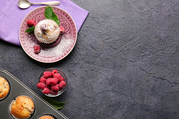 Plate with tasty raspberry muffin on dark background