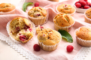 Tasty raspberry muffins on light background, closeup