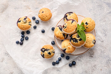 Composition with tasty blueberry muffins on light background