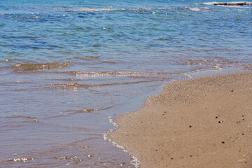 Clear waves on tropical sandy beach in Crete Greece.