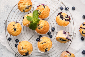 Grid with tasty blueberry muffins on light background, closeup