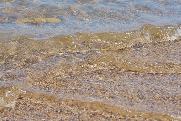 Fototapeta na wymiar Clear waves on tropical sandy beach in Crete Greece.