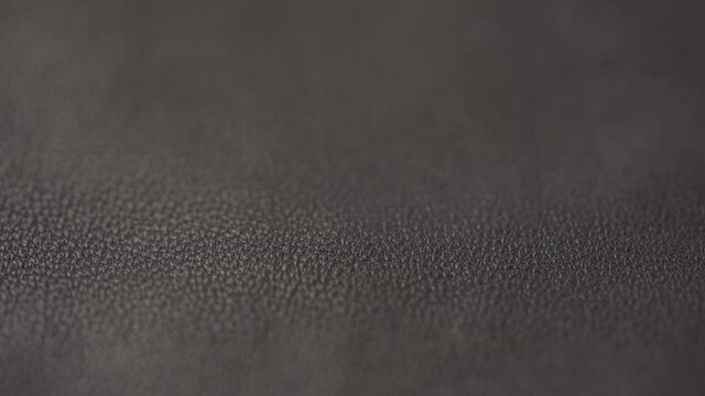 Slow motion closeup slide shot of soft gray brown leather