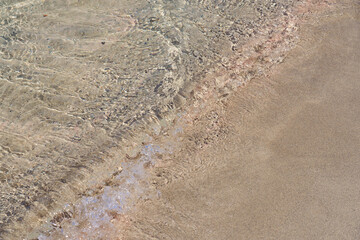 Clear waves on tropical sandy beach in Crete Greece.