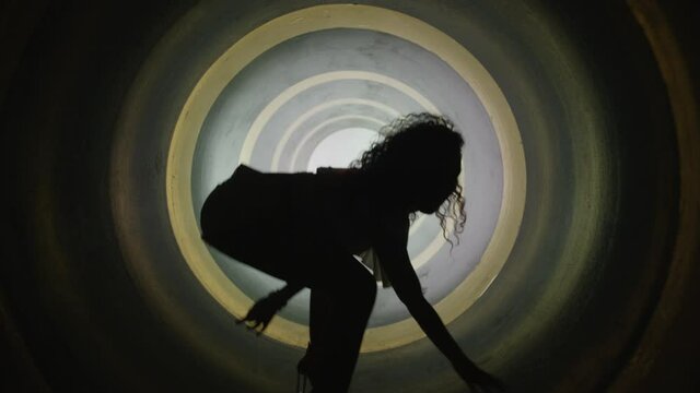 A silhouette of beautiful sexy girl , woman dancing inside round circle tube . Against colored & gray background . Real decoration . None computer graphics . Shot on Arri Alexa Cinema Camera in 4K .
